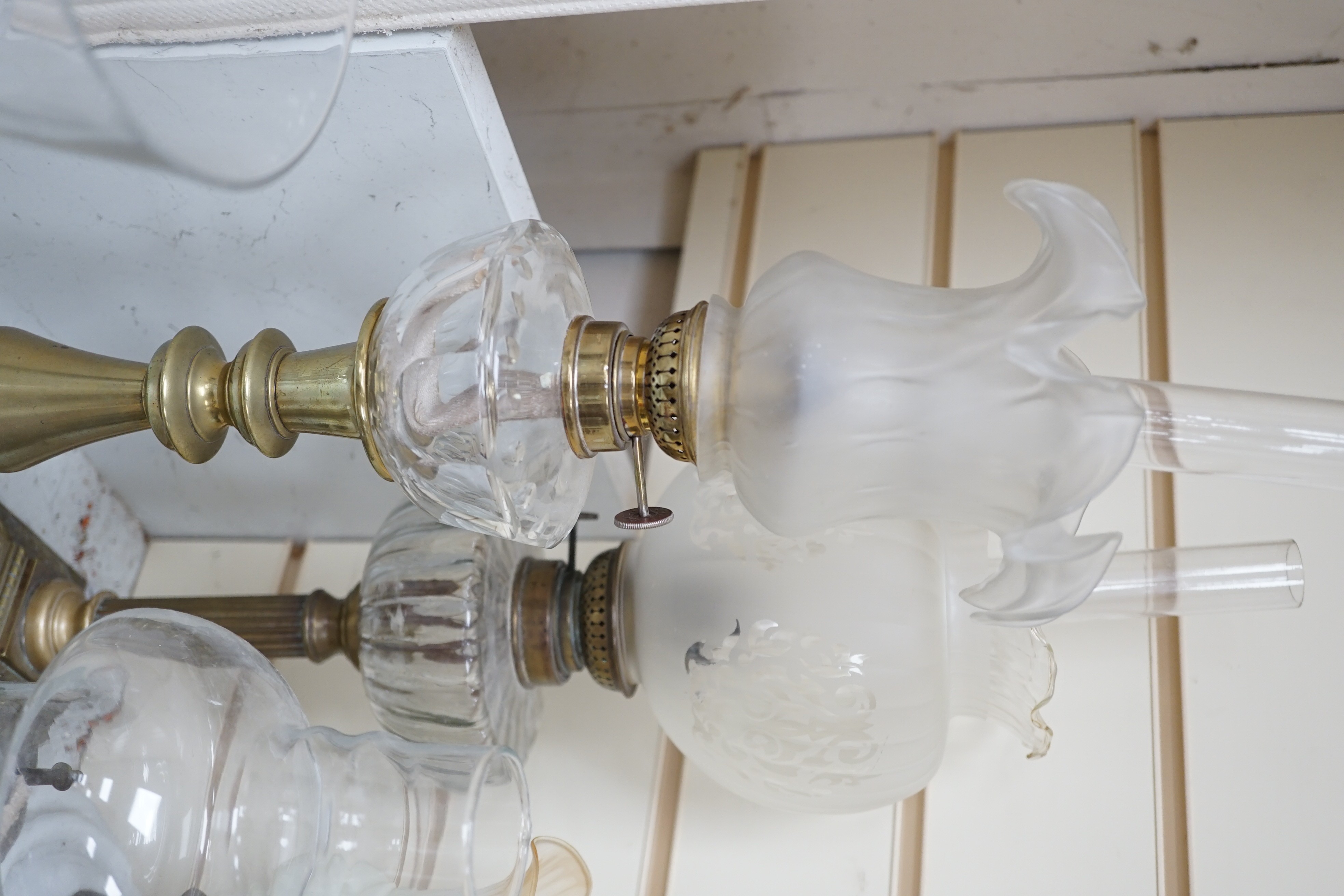 Four assorted glass and brass oil lamps, tallest 56cms high